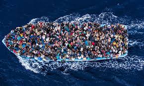 Una barcaza abarrotada de inmigrantes en aguas del Mediterráneo