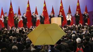 Un paraguas amarillo en señal de protesta ante las banderas oficiales de la República Popular de China